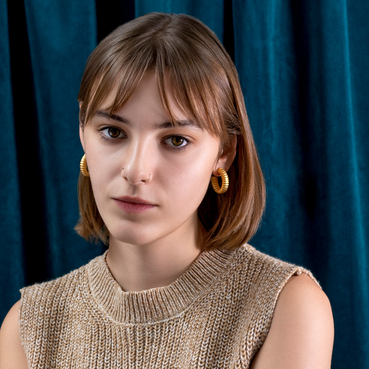 kobieta z krótkimi falowanymi włosami w klasycznych perłowych kolczykach