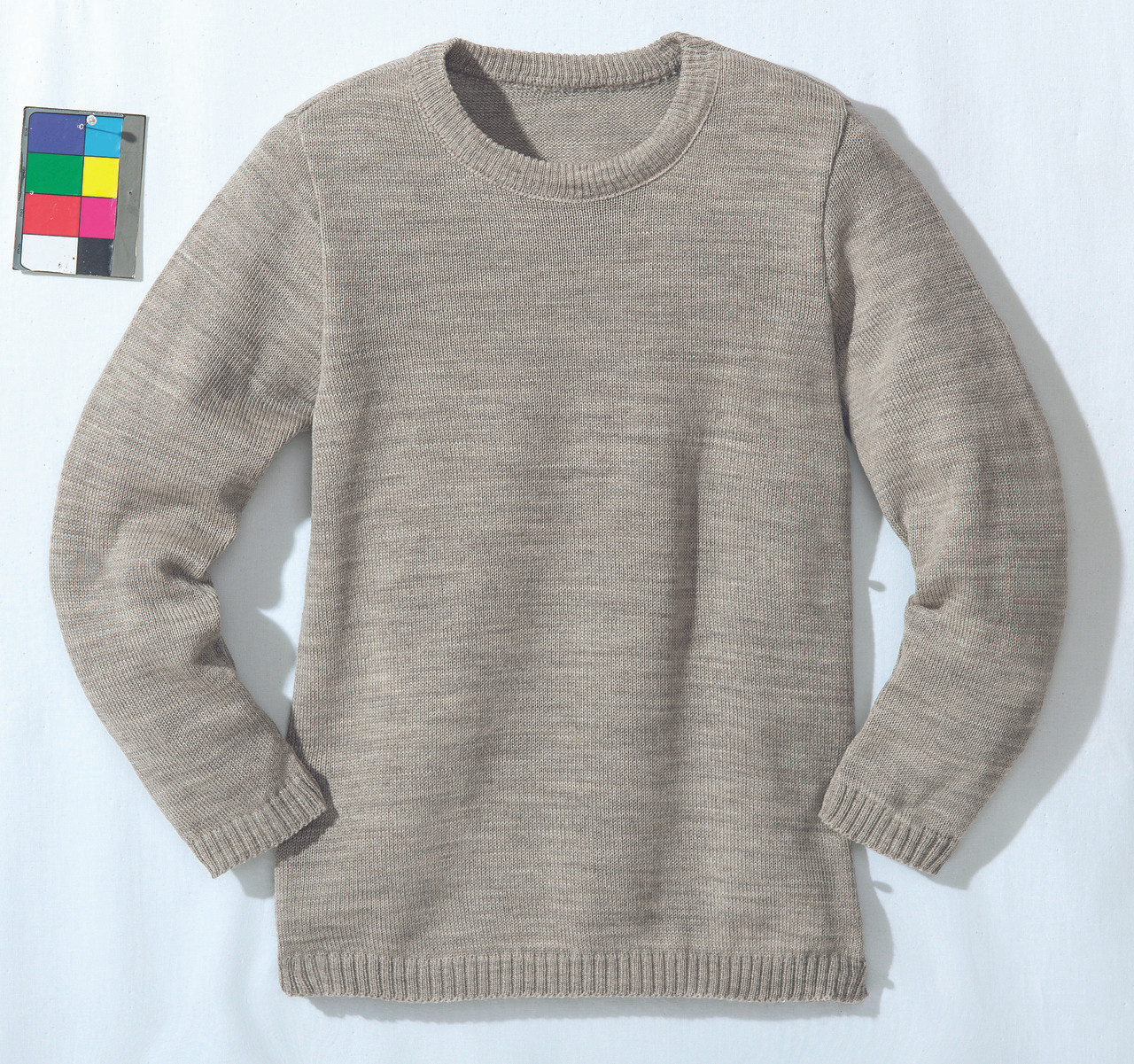 surowa wełna owcza w motku obok gotowego grubego drapiącego swetra