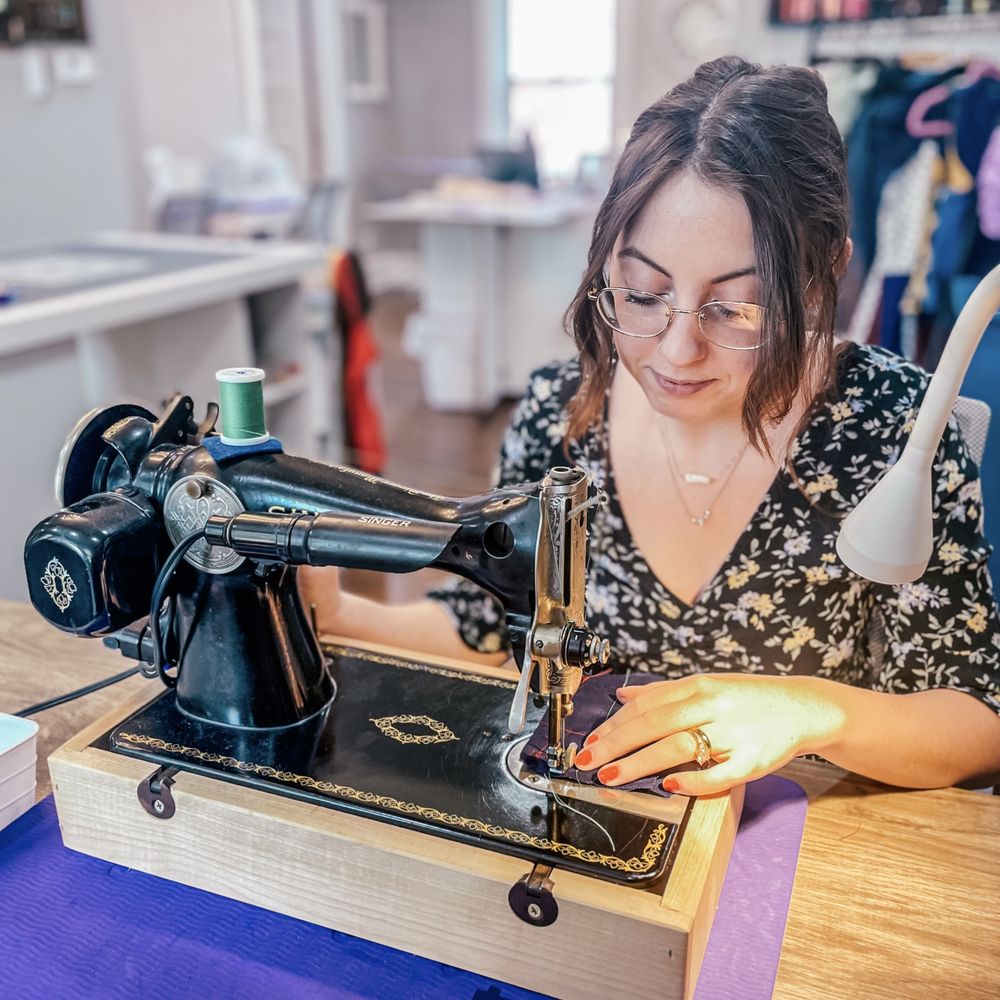 krawcowa mierząca obwód talii klientki taśmą krawiecką w lustrze