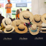 młoda kobieta przymierzająca różne kapelusze przed lustrem w garderobie