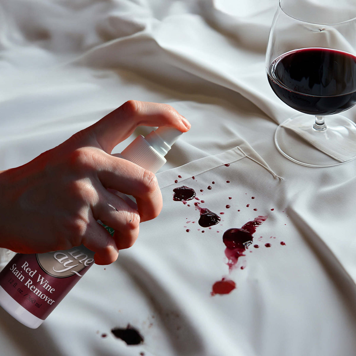 strumień zimnej wody spłukujący świeżą plamę na bawełnianej tkaninie