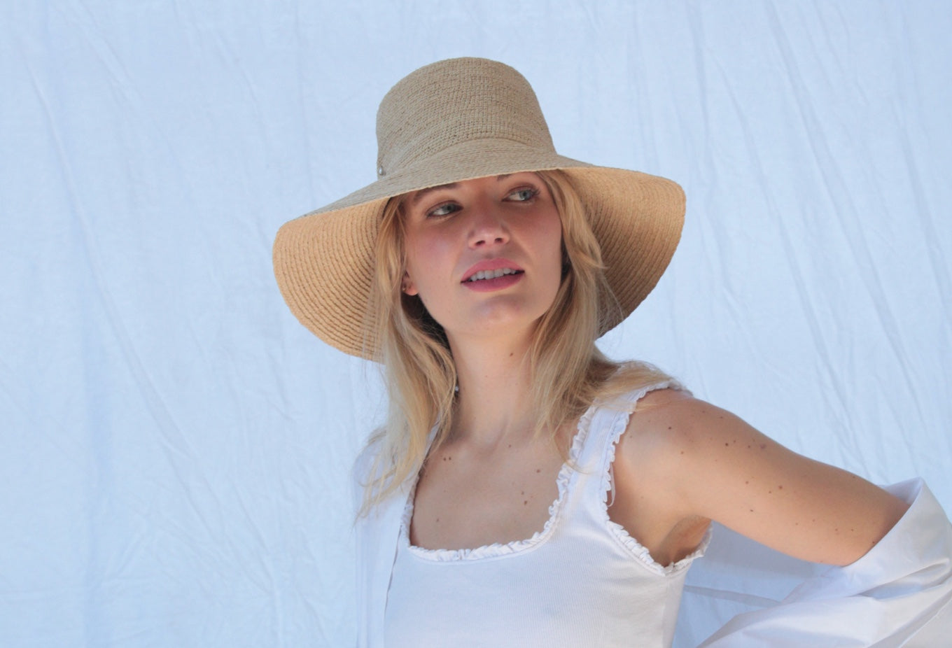 kobieta z trójkątną twarzą w dużym kapeluszu z asymetrycznym rondem