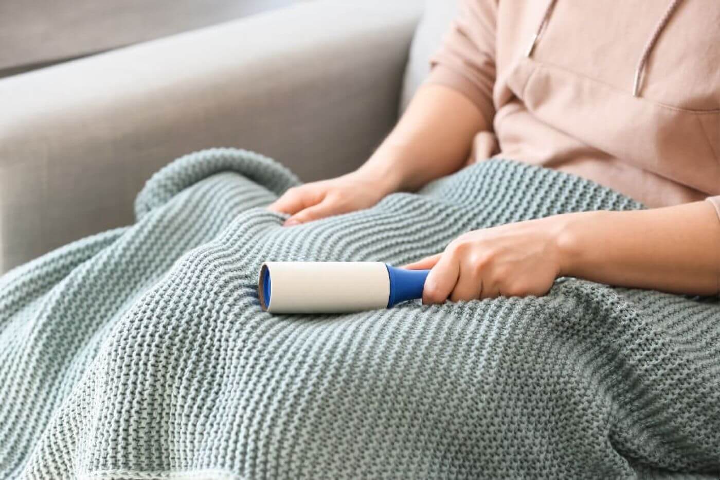 Kobieta w bluzce z akrylu z dużymi plamami potu pod pachami i na plecach