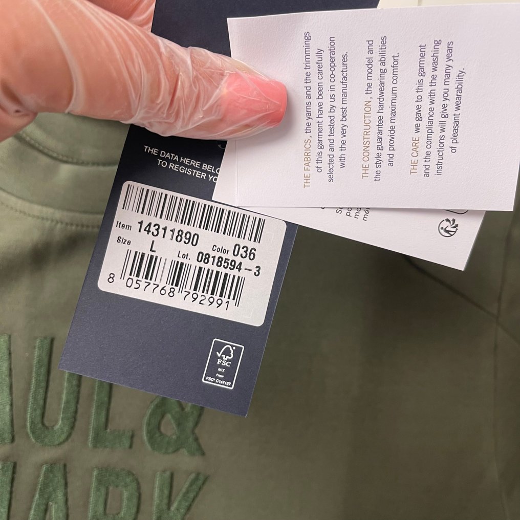 bluza z ikoną Cradle to Cradle leżąca obok zielonych liści na tle